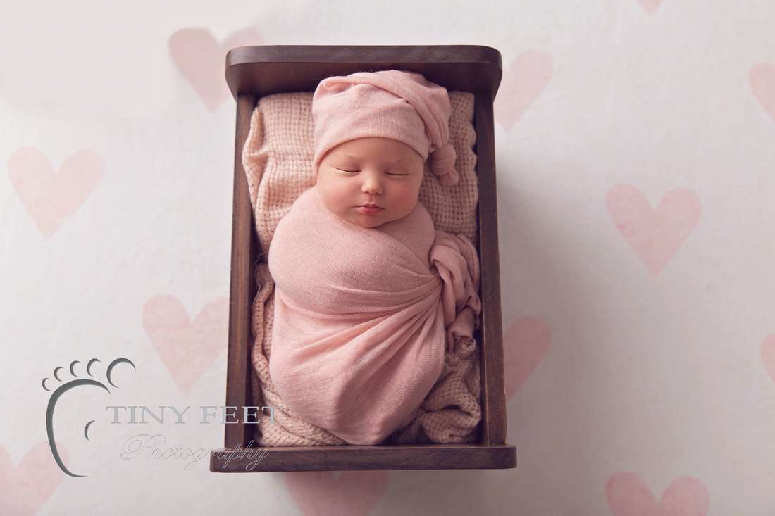 Tiny Feet Photography Perth newborn girl posed in Little Jar Big Dreams wooden bed in pink wrap